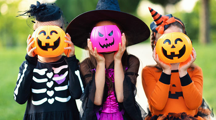 fun kids holding pumpkin buckets in front of their faces